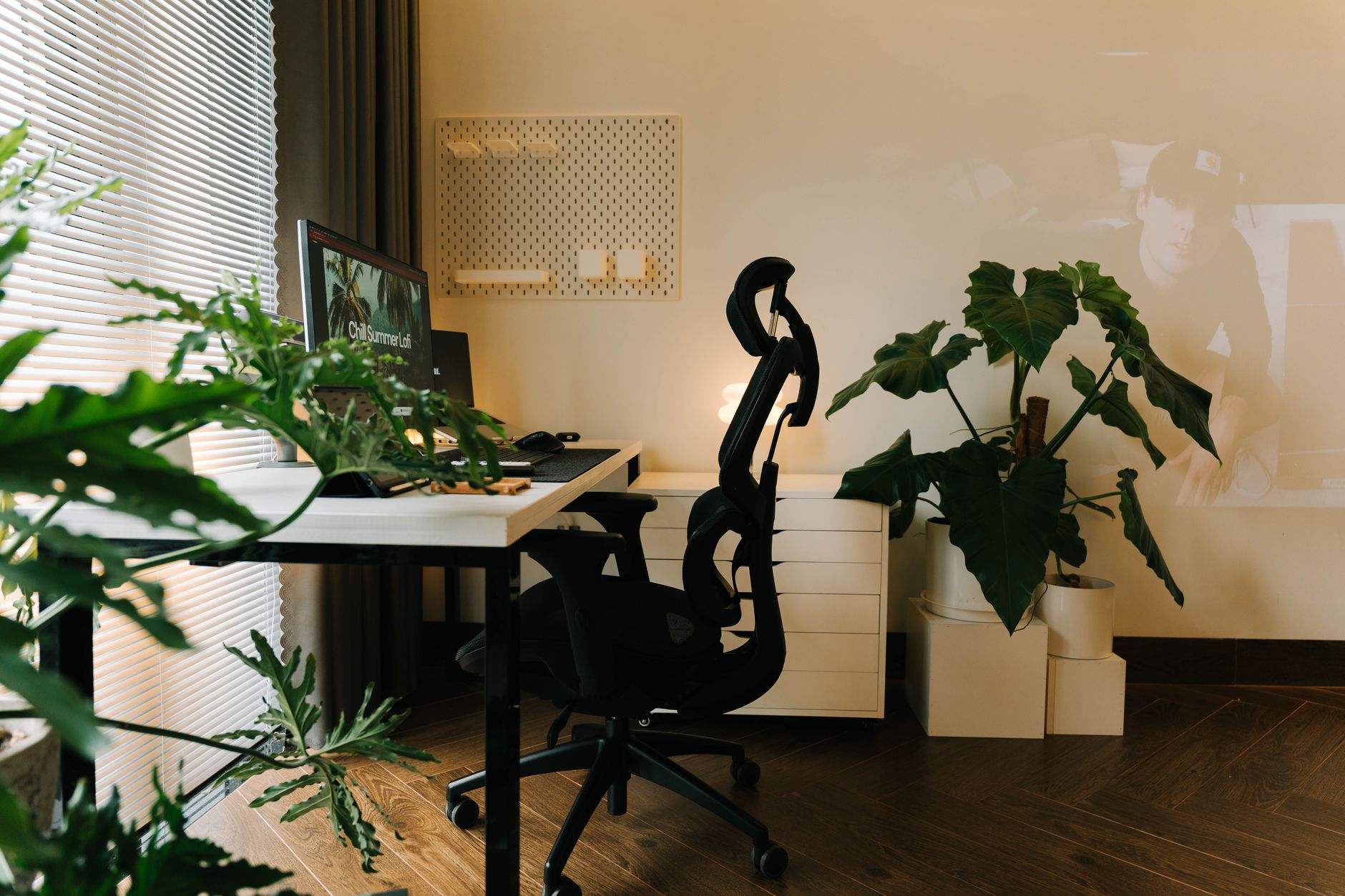 A stylish home office setup with plants and an ergonomic chair, set up for focused writing work.