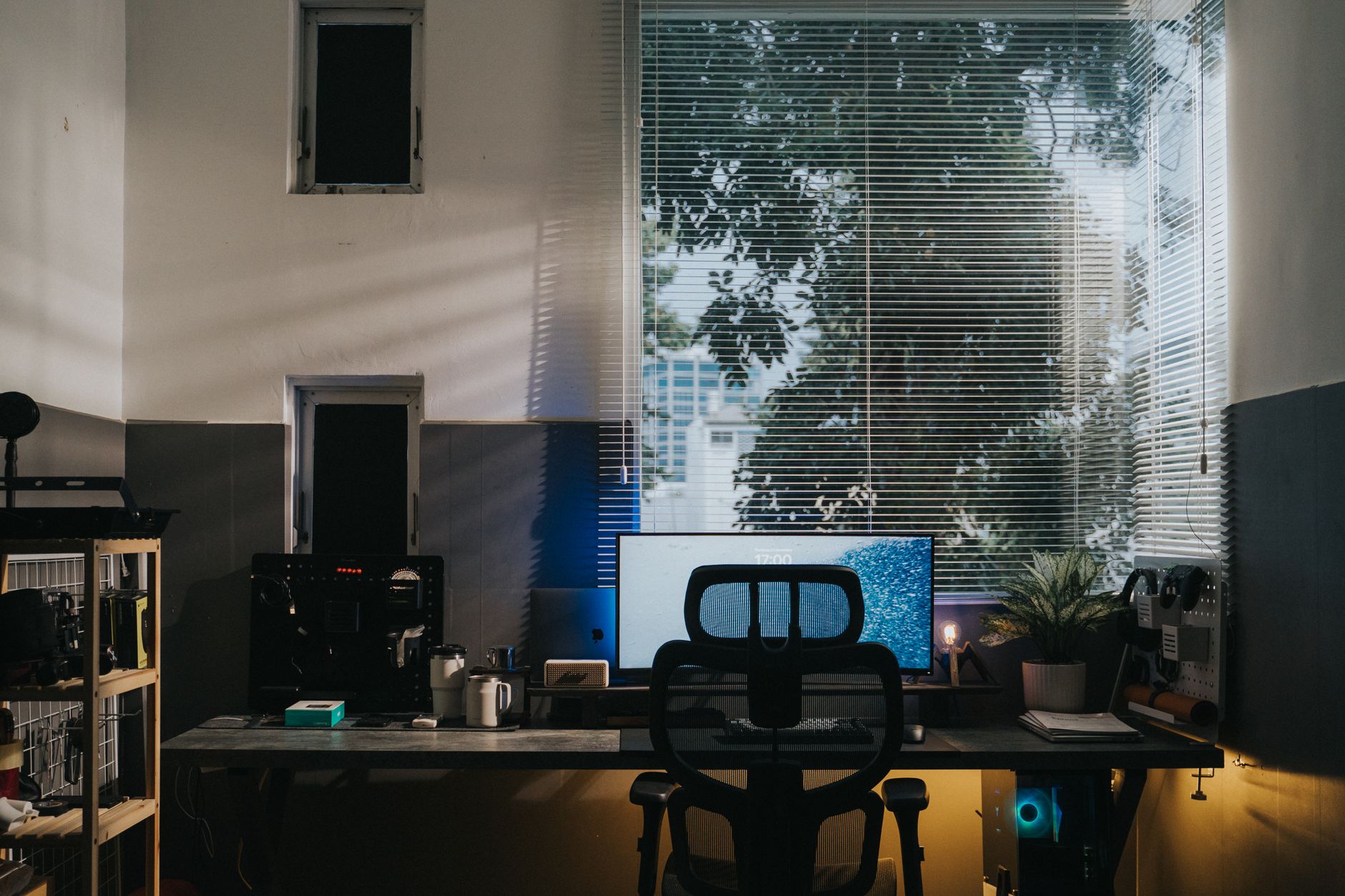A cozy office workspace with a desk, monitor, and natural light through blinds, ready for a day of client work.